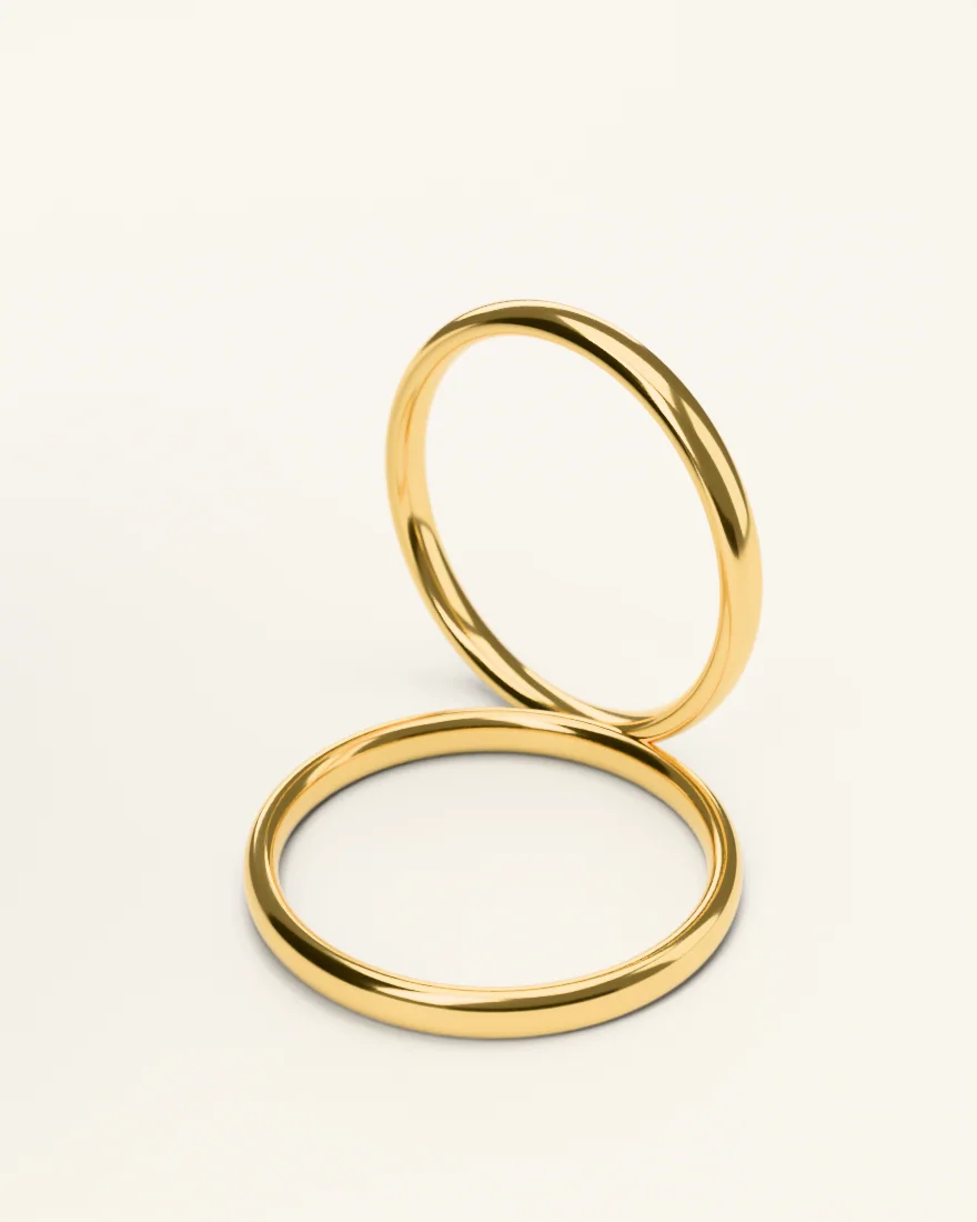 Two polished gold bangles, one standing and one lying flat