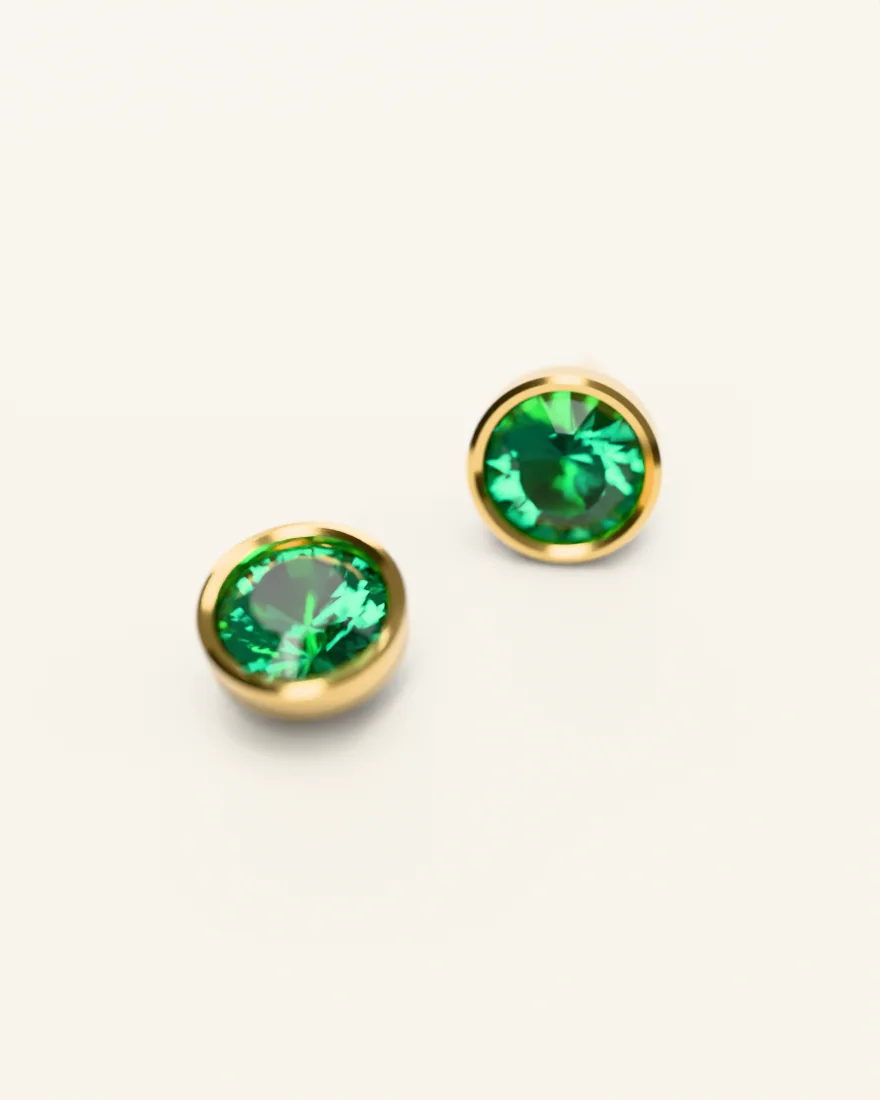 Pair of gold stud earrings set with round emeralds