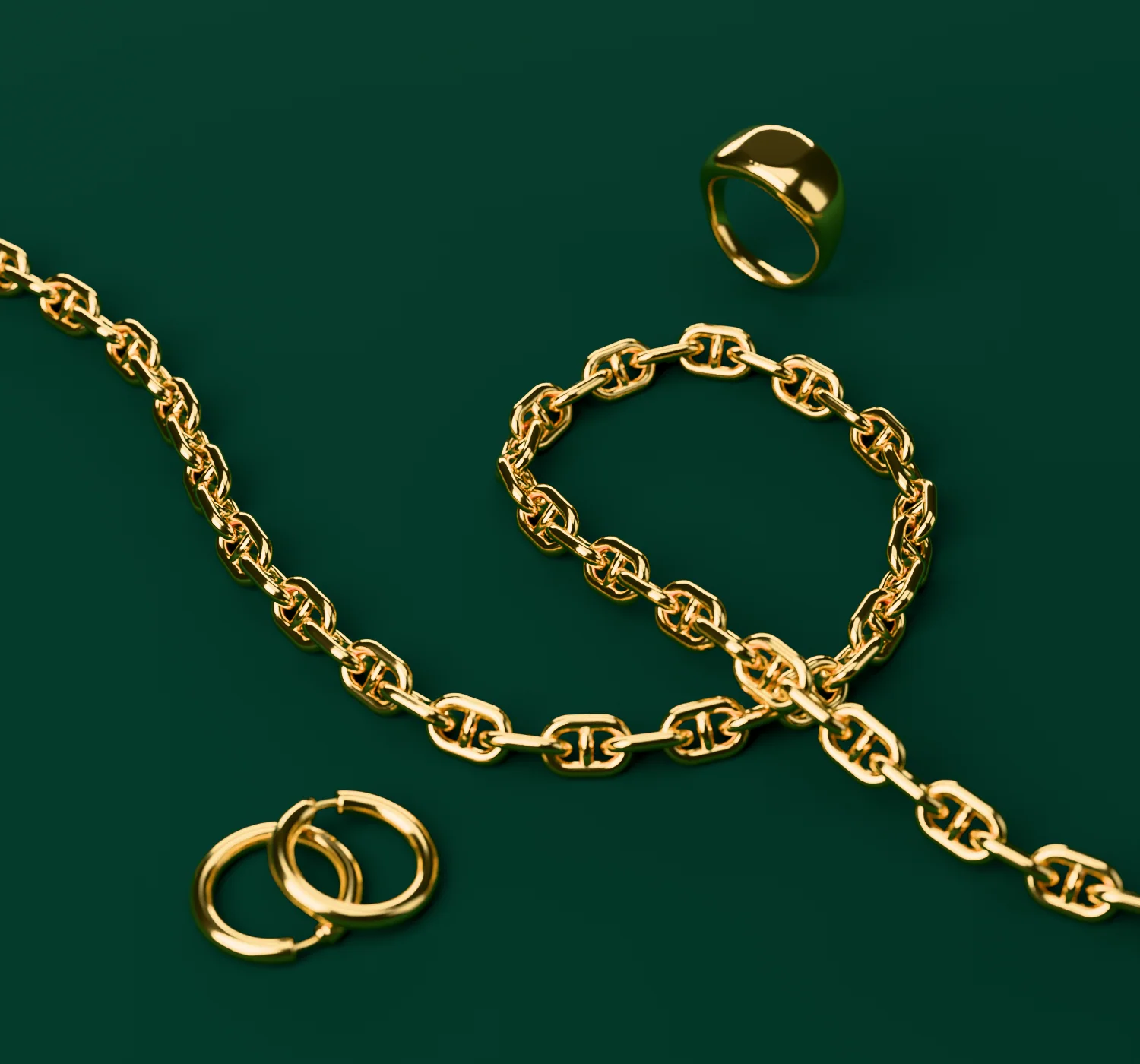 A gold mariner chain, a pair of hoops and a signet ring on green velvet